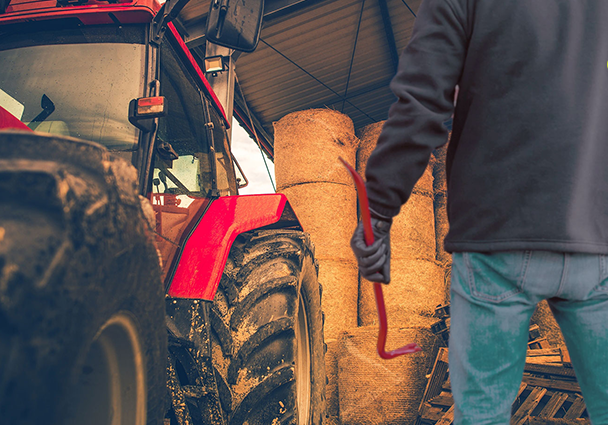 man stood next to tractor holding a crowbar